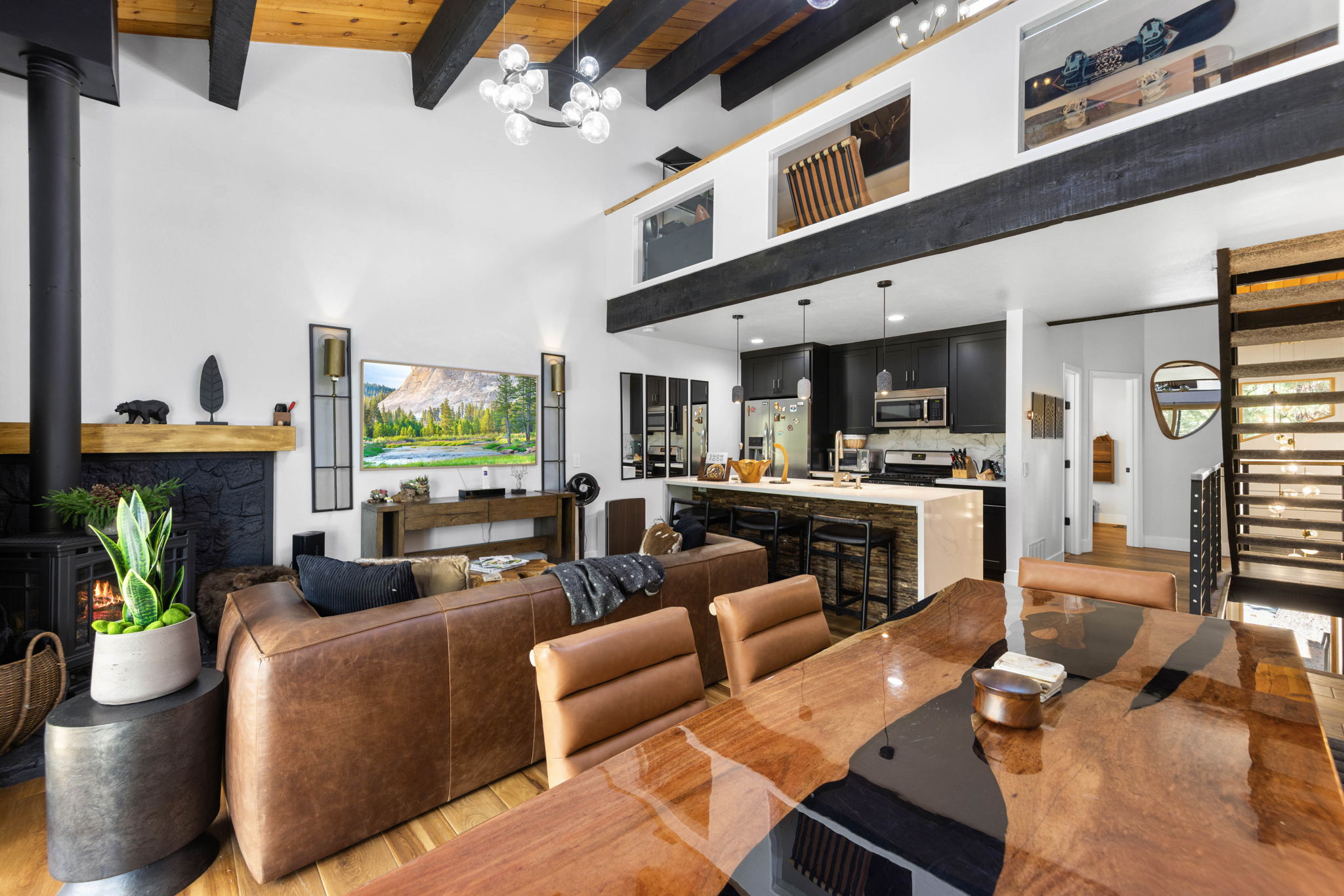 Cubs Manor great room after renovation, black kitchen and loft under blackened beams