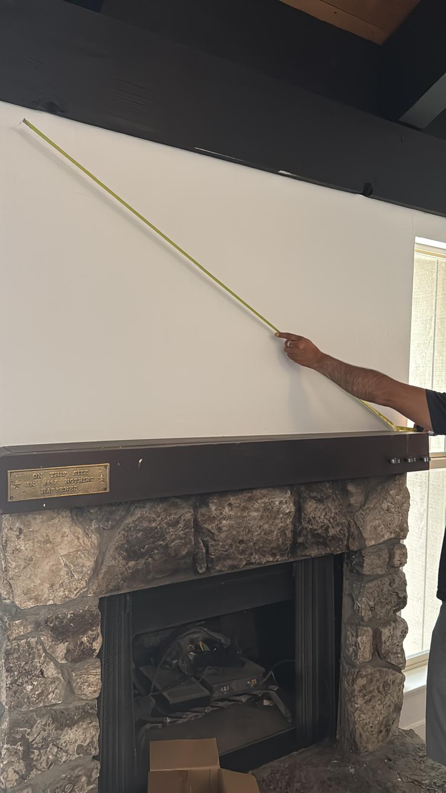 Measuring a fireplace wall on a site visit